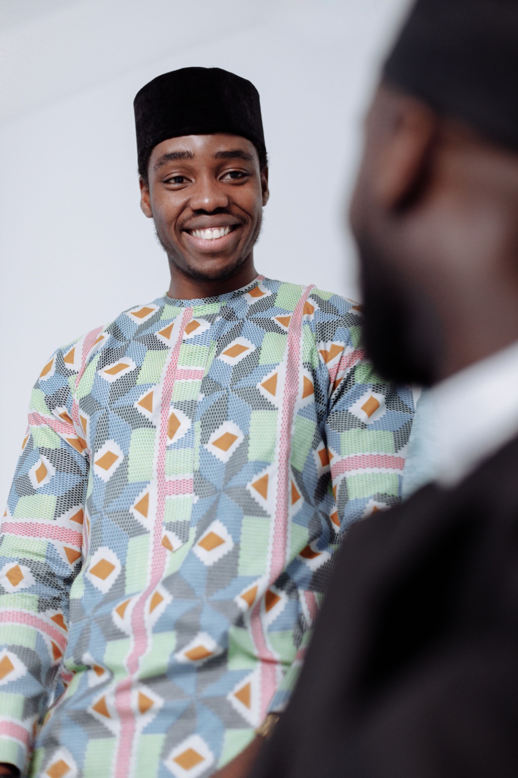 An African man in agbada in reflection, golden hour light